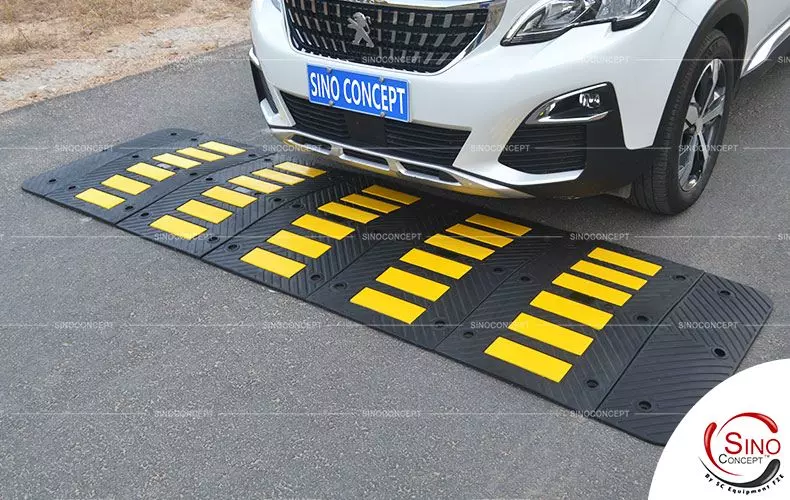 A black speed hump with yellow reflective films to reduce speed.