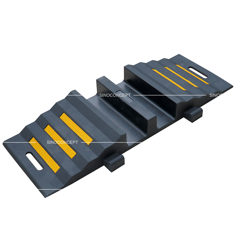 A black rubber hose protector ramp with yellow reflective films to protect hoses or cables.