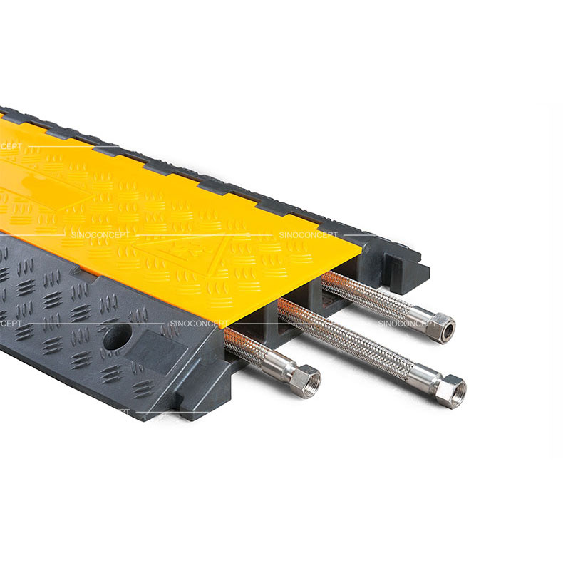 A 3-channel cable ramp made of rubber with anti-slip surface and yellow plastic covers to protect hoses or cables.