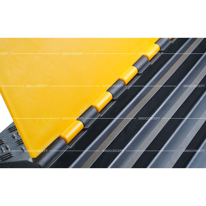A detailed picture of a 5-channel rubber cable ramp with yellow plastic lids.