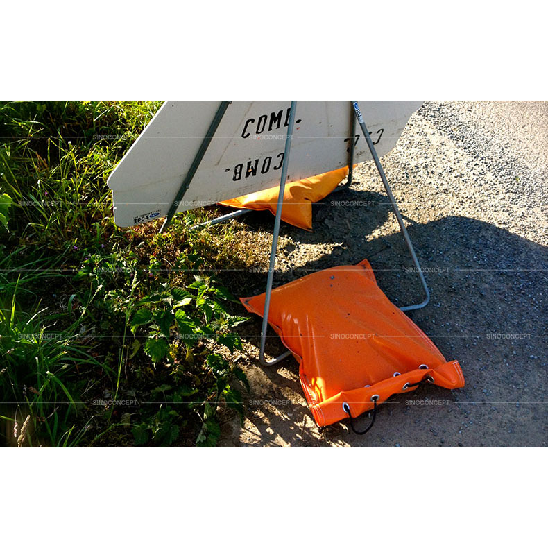 Orange temporary sandbags made of strong UV resistant PVC material used on road to fix signs for traffic safety