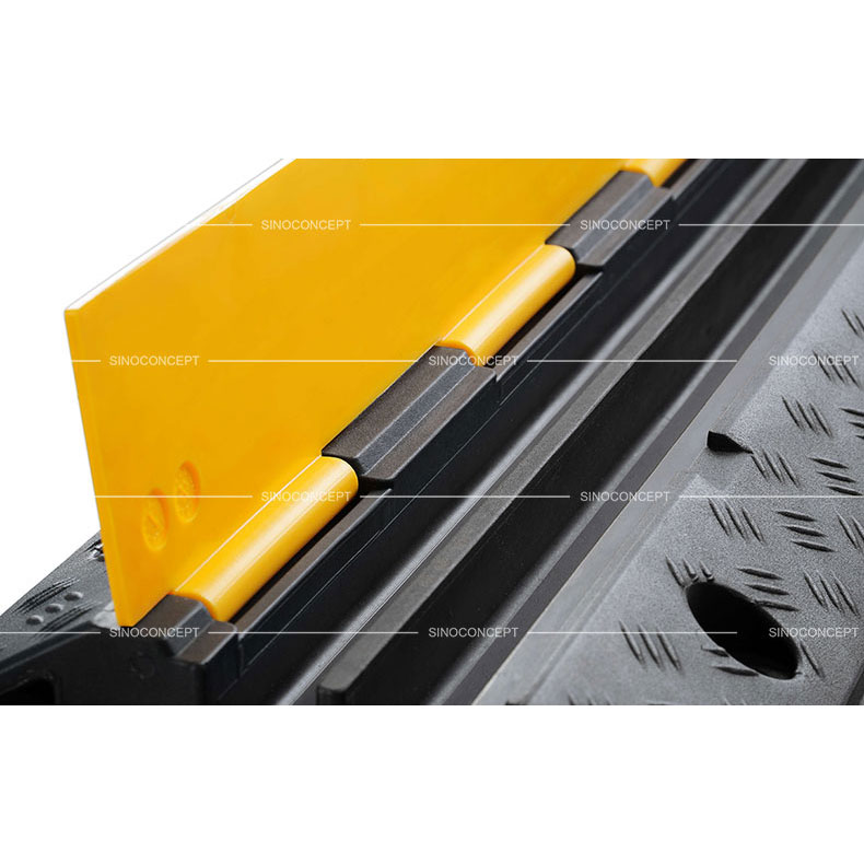 A detailed picture of a two-channel rubber cable ramp with yellow plastic lids.
