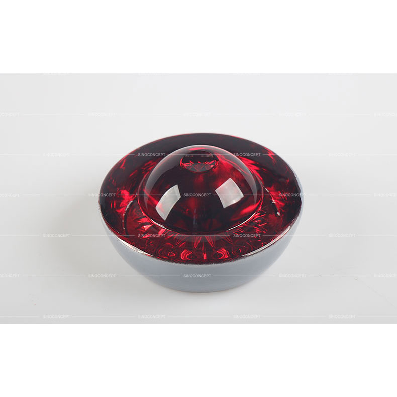 Big red glass road safety stud also called reflective road stud made of glass and steel used on roads for road safety