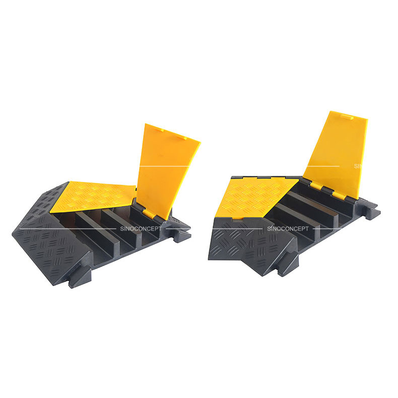 Cable protectors angle parts made of black recycled rubber and covered with yellow plastic lids to protect cables or hoses.