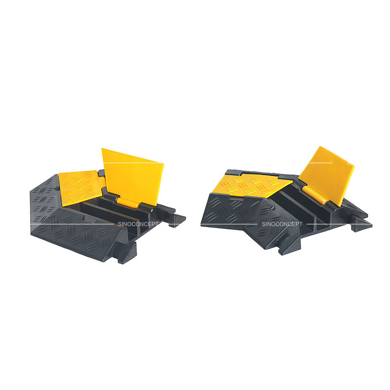 Two channels cable covers angle parts made of black vulcanized rubber and covered with yellow plastic lids to protect cables or hoses.