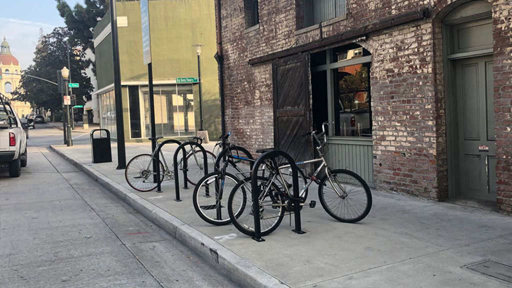 Black U-shaped bike parking racks installed on the ground for bike parking.