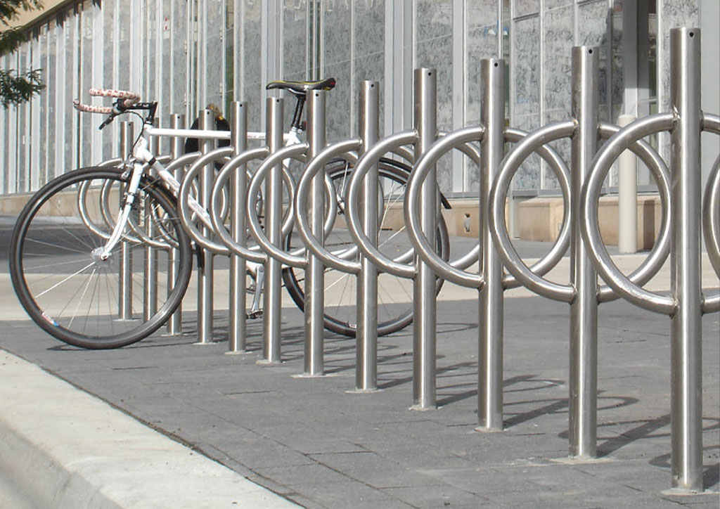 Several post and ring bike racks mounted on the ground for bike parking.